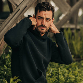 fit model wearing The Nomad Hoodie in Navy Twill, near plants