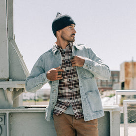fit model wearing The Ojai Jacket in Washed Denim, layered over flannel, looking right