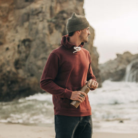 fit model wearing The Rib Beanie in Forest Heather, holding water