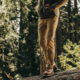 fit model wearing the all day pant, walking on log