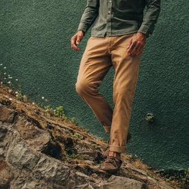 fit model wearing the Foundation Pant, standing on rocks