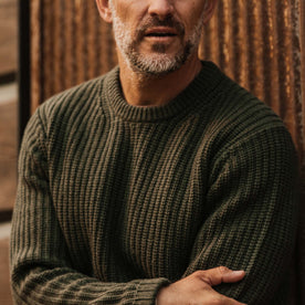 fit model wearing The Wharf Sweater in Dark Olive with arms crossed