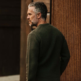 fit model wearing The Wharf Sweater in Dark Olive looking left