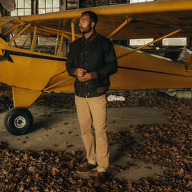 fit model in front of a plane in The Bomber Jacket in Bark EverWax
