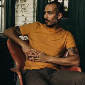 fit model sitting in The Cotton Hemp Tee in Mustard