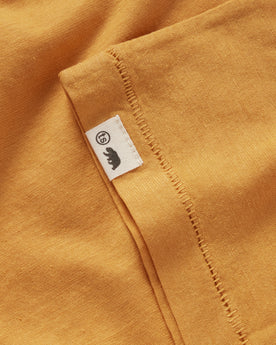 material shot of the TS tag on the sleeve of The Cotton Hemp Tee in Mustard, Knits by Taylor Stitch