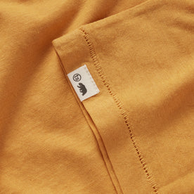 material shot of the TS tag on the sleeve of The Cotton Hemp Tee in Mustard