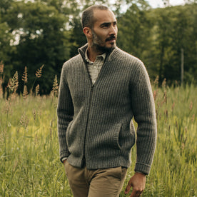 fit model walking through a field wearing The Fisherman Full-Zip in Taupe