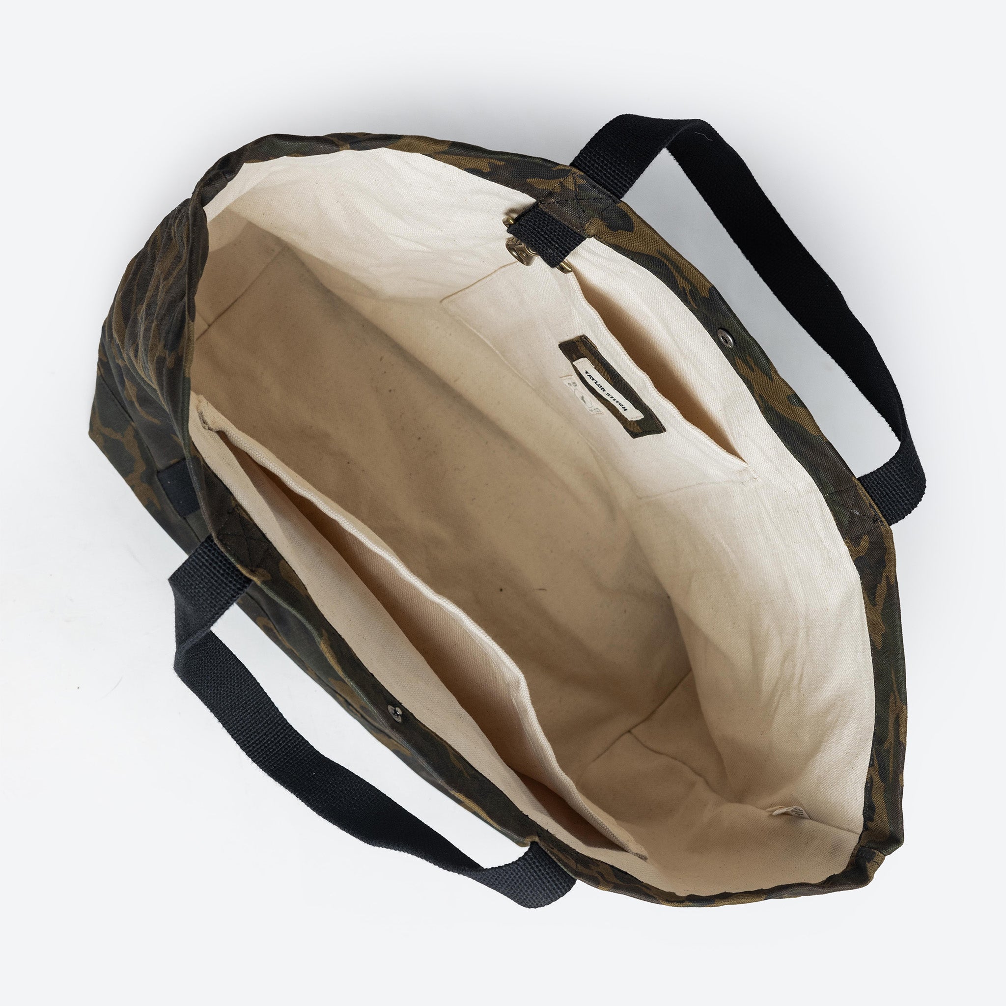 flatlay of The Market Tote in Camo Boss Duck, shown open from the top, Accessories by Taylor Stitch