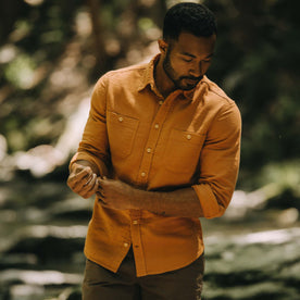 fit model adjusting the sleeves on The Utility Shirt in Russet Double Cloth
