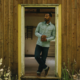 fit model leaning against a door frame in The Western Shirt in Indigo Stripe