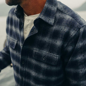 fit model carrying logs wearing The Yosemite Shirt in Navy Shadow Plaid