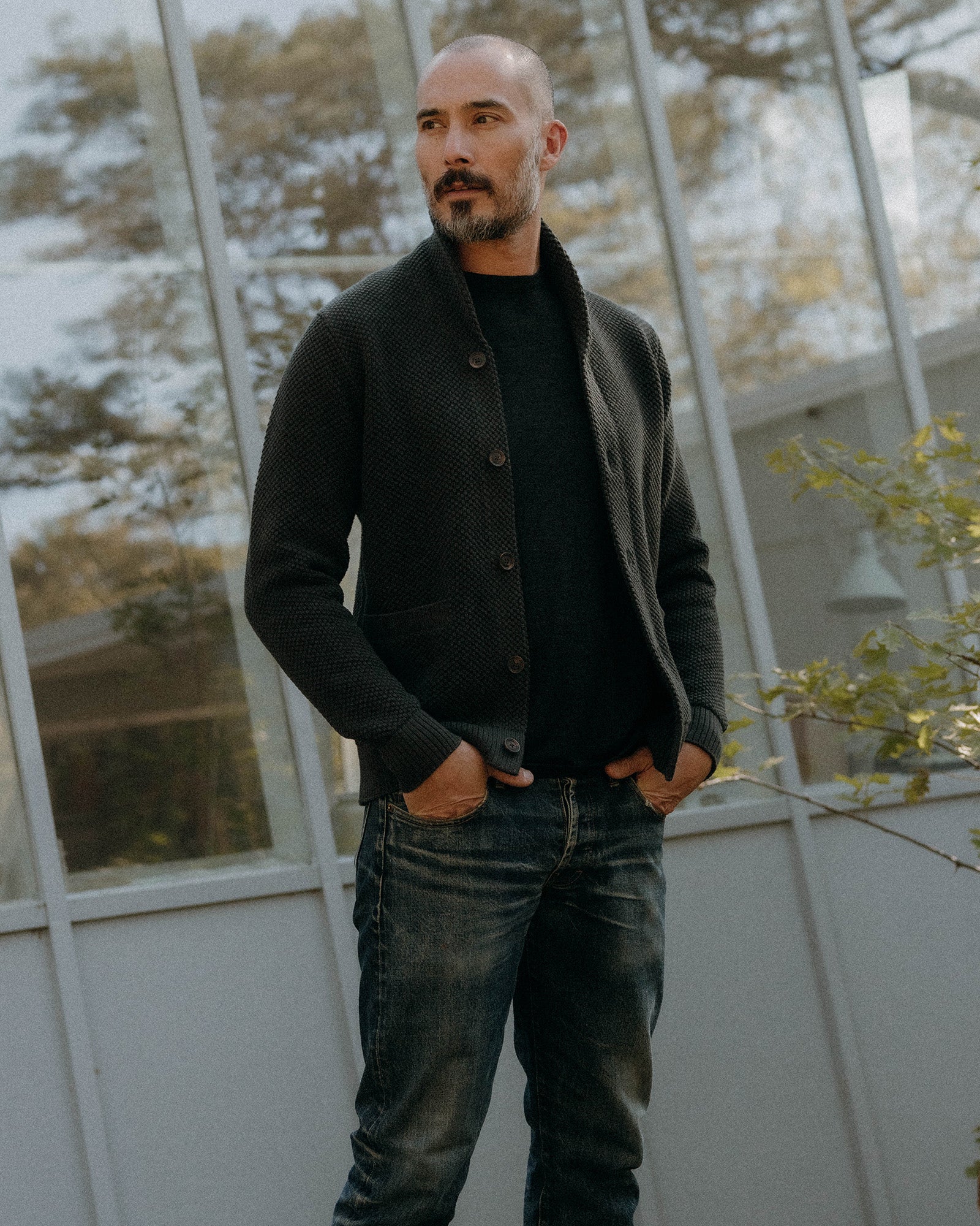 fit model sitting in The Crawford Cardigan Sweater in Charcoal, Knits by Taylor Stitch