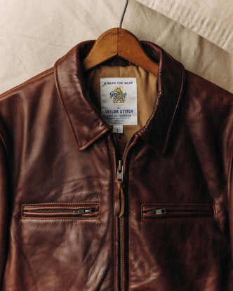 fit model sitting on a motorcycle in The Moto Jacket in Espresso Steerhide