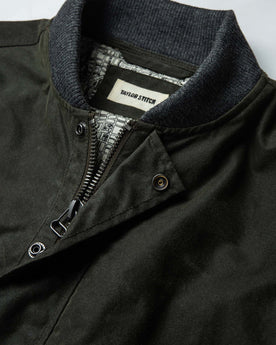 material shot of The Bomber Jacket in Waxed Olive from the front showing label and collar, Outerwear by Taylor Stitch