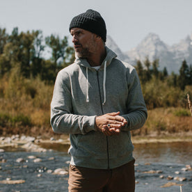 fit model wearing The Fillmore Hoodie in Ash Double Knit in front of a lake