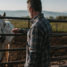 fit model wearing The Ledge Shirt in York Plaid, touching horse