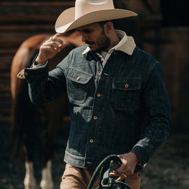fit model wearing The Lined Long Haul Jacket in Green Cast Denim on a ranch