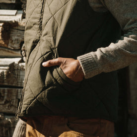 Fit model wearing The Quilted Bomber Vest in Olive Dry Wax with close up of quilted texture
