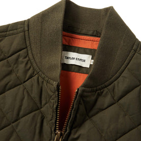 material shot of The Quilted Bomber Vest in Olive Dry Wax showing interior label