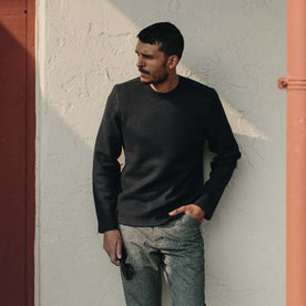 Fit model wearing The Weekend Crewneck in Navy Boiled Wool leaning up against a wall