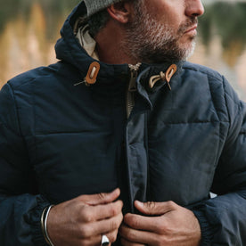 fit model wearing The Whitney Parka in Navy buttoning front placket