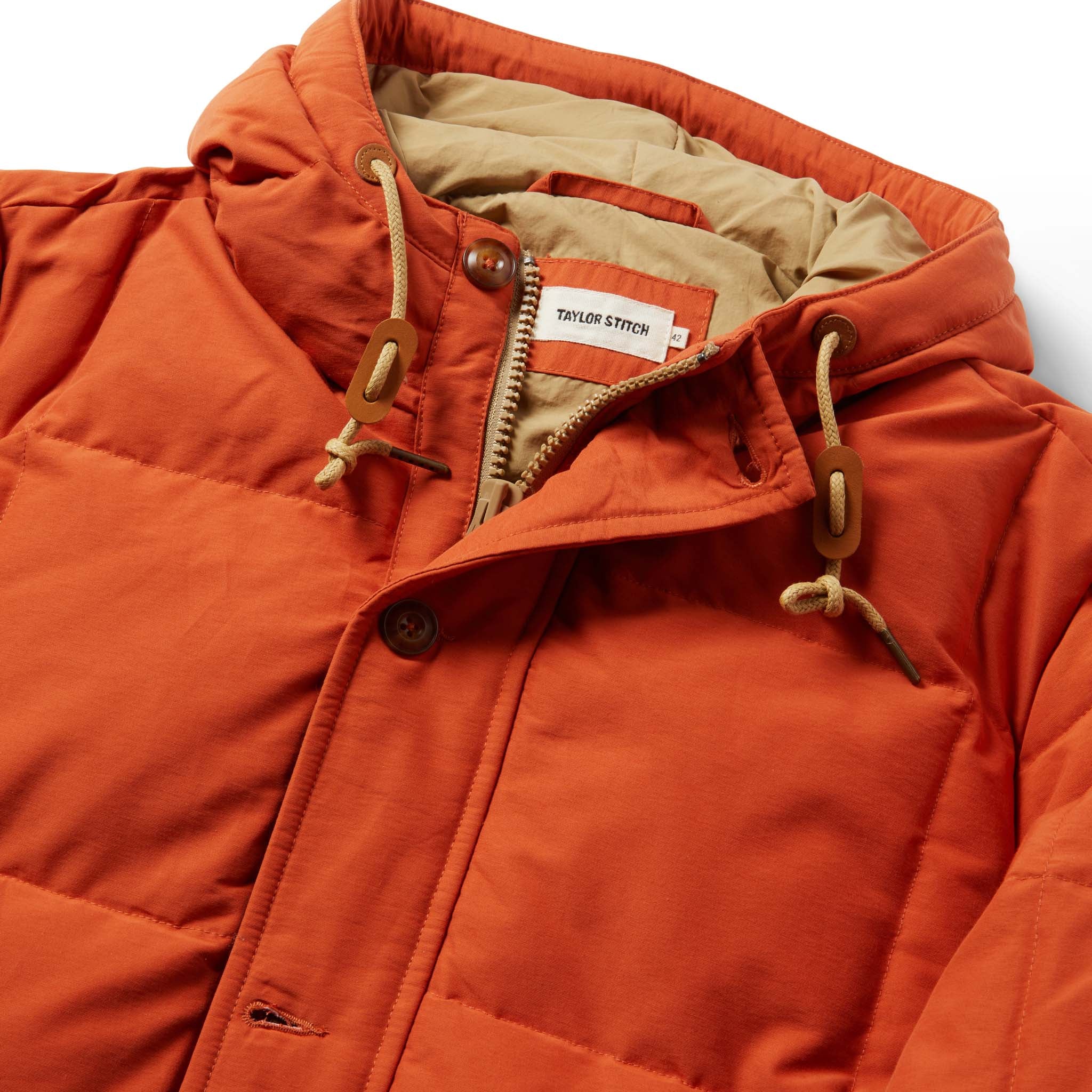 material shot of The Whitney Parka in Dusty Orange showing the interior label, Outerwear by Taylor Stitch
