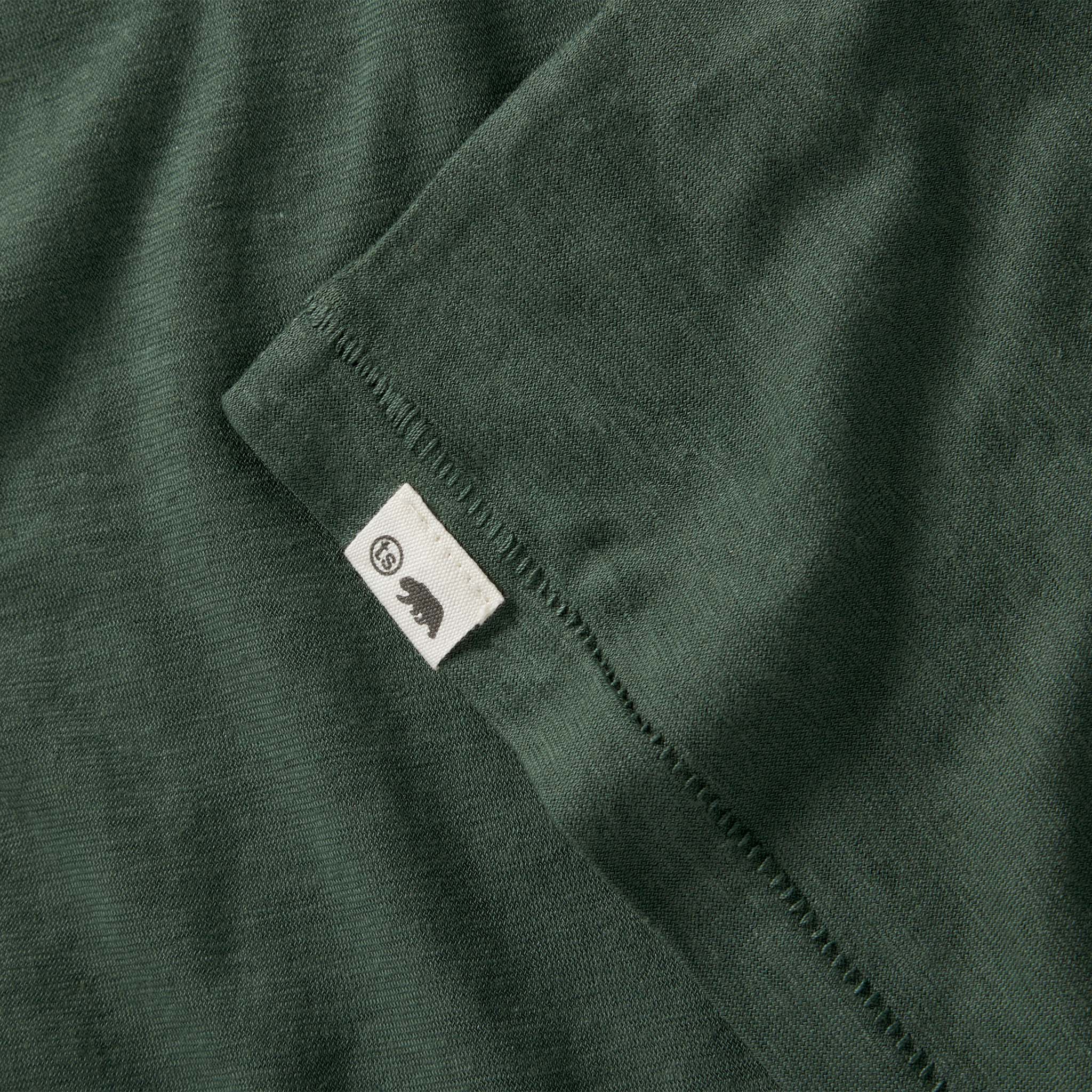 material shot of the logo on The Cotton Hemp Long Sleeve in Pine, Knits by Taylor Stitch