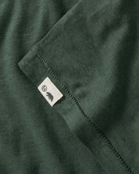 material shot of the logo on The Cotton Hemp Long Sleeve in Pine, Knits by Taylor Stitch