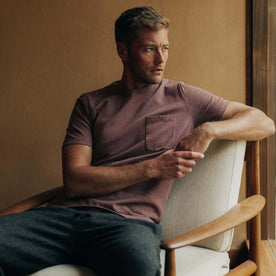 fit model sitting wearing The Heavy Bag Tee in Burgundy