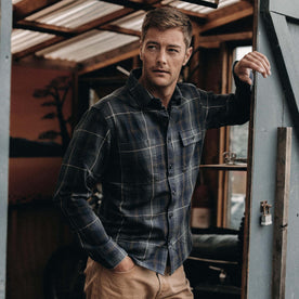 fit model leaning against a door in The Moto Utility Shirt in Shale Plaid