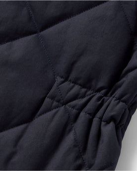 material shot of the cinched detail on The Quilted Bomber Vest in Navy Dry Wax, Outerwear by Taylor Stitch