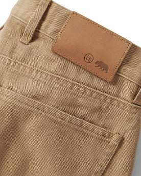material shot of the back leather flap on The Slim All Day Pant in Washed Tobacco Selvage, Bottoms by Taylor Stitch