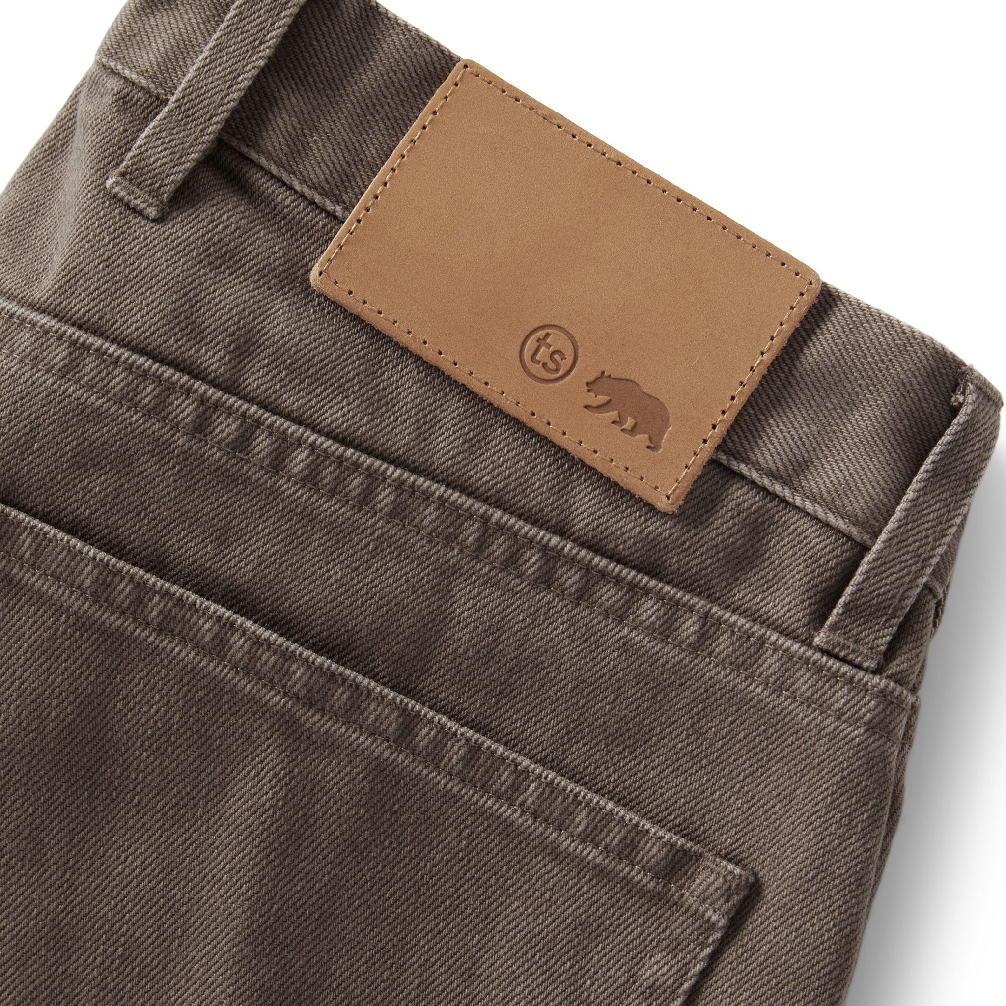 material shot of the leather detail on The Slim All Day Pant in Washed Walnut Selvage, Bottoms by Taylor Stitch