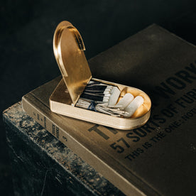 editorial image of The Tinder Box in Brass open with products inside on a book