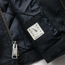 material shot of the zipper and Boss Duck logo on The Workhorse Vest in Coal Boss Duck