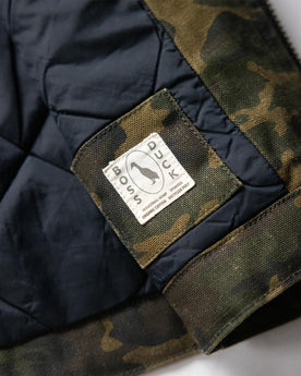 material shot of the Boss Duck logo on The Workhorse Vest in Camo Boss Duck, Outerwear by Taylor Stitch