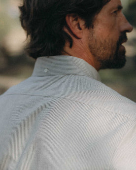 fit model showing off buttons on The Jack in Coal Jaspe University Stripe Oxford, Wovens by Taylor Stitch