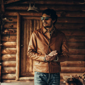 fit model wearing The Cuyama Jacket in Cognac, hands clasped by cabin