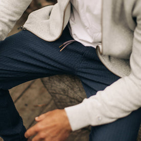 our fit model wearing The Après Pant in Navy Seersucker—cropped shot, sitting down