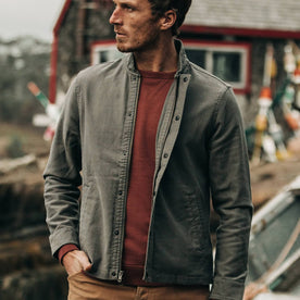 fit model wearing The Bomber Jacket in Charcoal Jungle Cloth, hand in pocket, looking left of camera