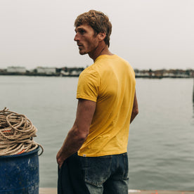 fit model wearing The Cotton Hemp Tee in Gold, back shot near water