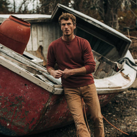 fit model wearing The Crewneck in Brick Red Terry, leaning against boat