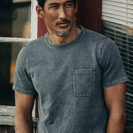 fit model wearing The Heavy Bag Tee in Charcoal, cropped shot forehead down
