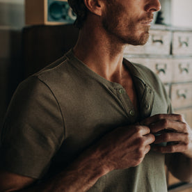 fit model wearing The Short Sleeve Heavy Bag Henley in Washed Olive, cropped of chest