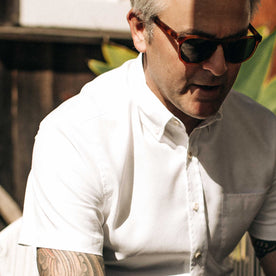 our fit model wearing The Short Sleeve Jack in Washed White Oxford outside sitting down