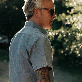 our fit model wearing The Short Sleeve Popover in Blue Chambray—cropped shot from the right