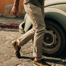 fit model wearing The Democratic All Day Pant in Aluminum Bedford Cord, cuffed next to car