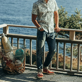 fit model wearing The Democratic Jean in Organic Selvage 12-month Wash, hand in pocket, cuffed with sneakers