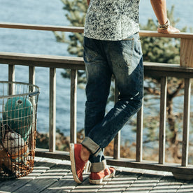 fit model wearing The Democratic Jean in Organic Selvage 12-month Wash, back shot looking out to water